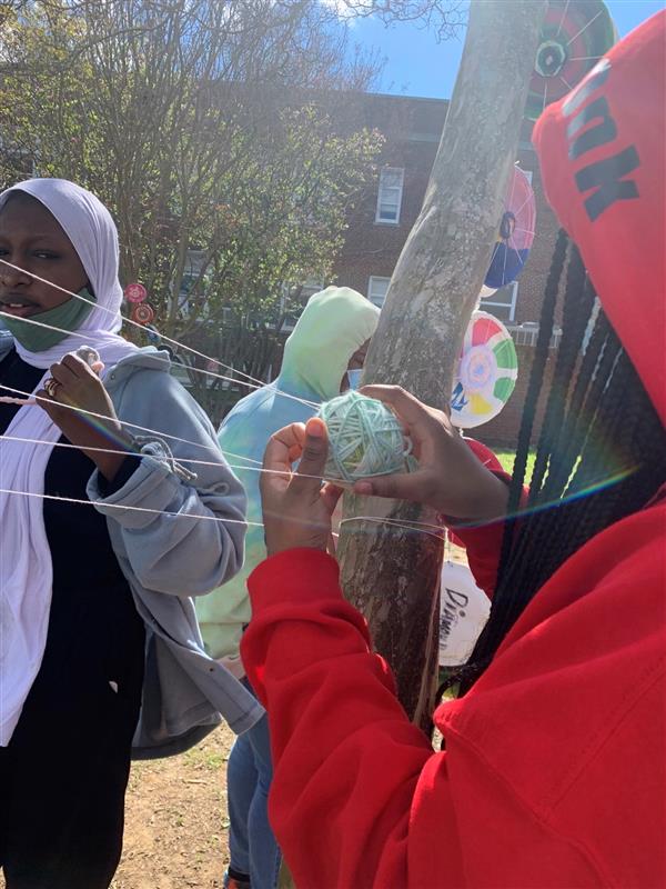 Students engaging in an outdoor visual art project with yarn